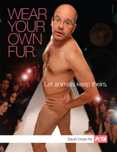 David Cross is naked and on a fashion runway. He is striking a pose and looking at the camera with a silly face.