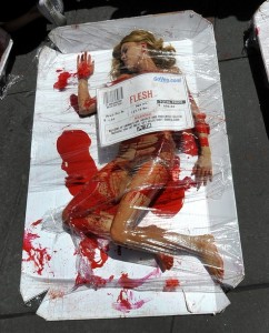 Woman laying under plastic wrap like a piece of meat with a bar code.