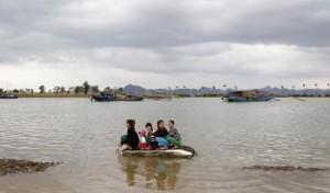 Filipino women cling to wreckage in rising waters.