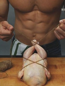 Hypermuscular man is binding the corpse of a chicken