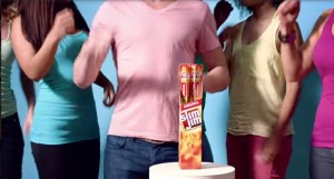 Man dancing behind Slim Jim display surrounded by several dancing women.