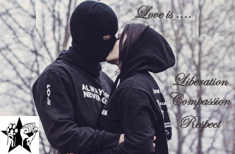 Man in ski mask kisses woman in black hoodie