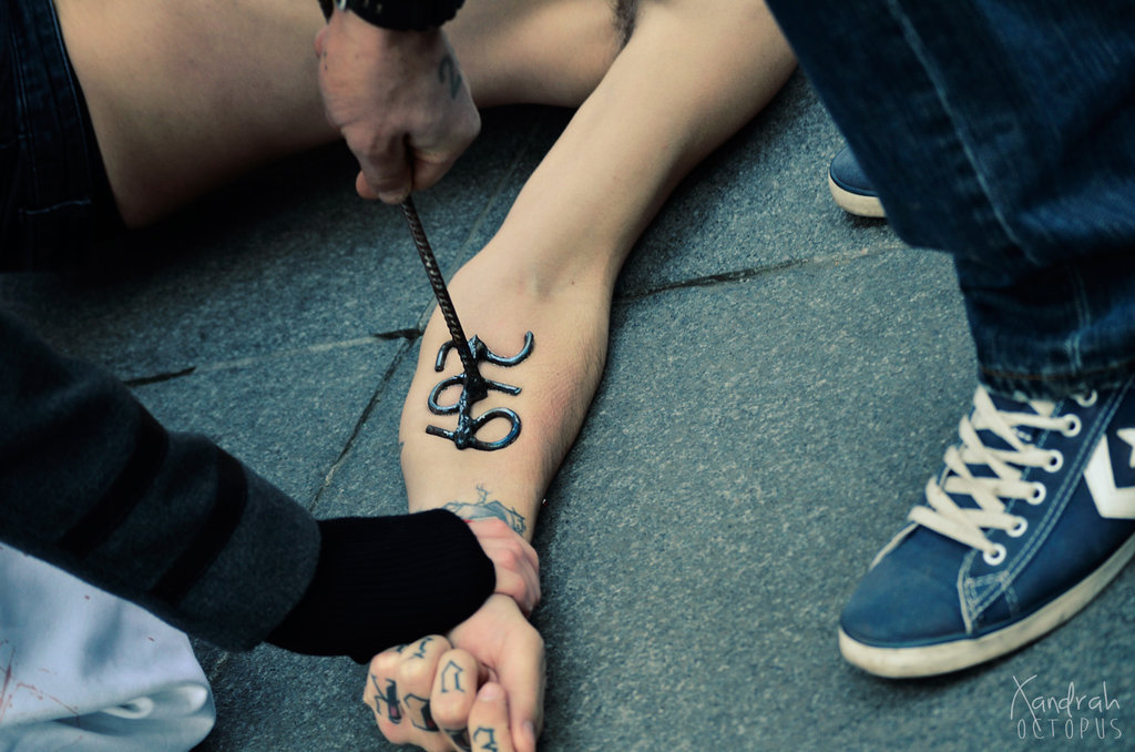 Arm being held down while branded with "269"